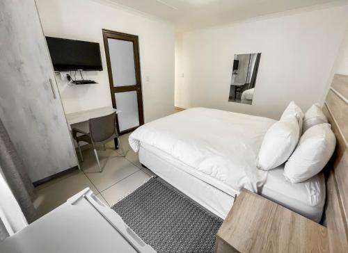 una camera d'albergo con letto e scrivania di Onamungundo Backpackers a Walvis Bay