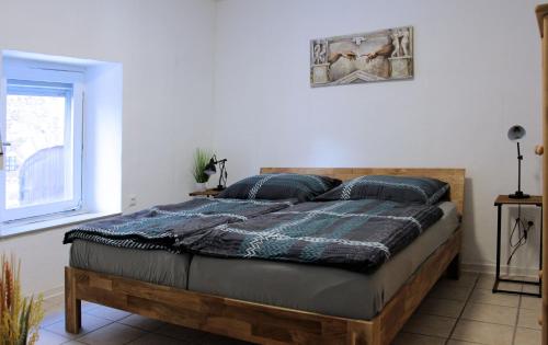 a bedroom with a bed with a wooden frame at Haus am Burgring in Mürlenbach