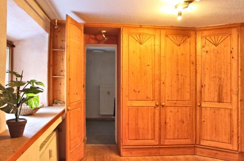 a kitchen with wooden cabinets and a hallway at Haus am Burgring in Mürlenbach