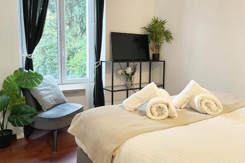 een slaapkamer met een bed, een tv en een stoel bij Elegant and confortable T2 - Ivry & Paris in Ivry-sur-Seine