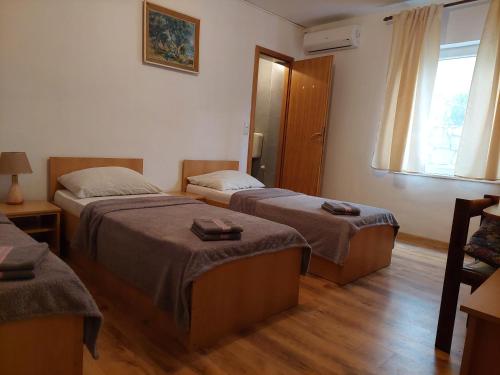 a hotel room with two beds and a window at Royal Apartments in Neum