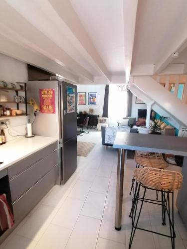 Il comprend une cuisine équipée d'un réfrigérateur et d'une table. dans l'établissement Le super duplex des halles, à Sète