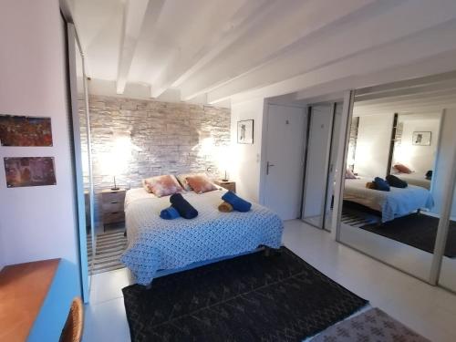 une chambre avec un lit et un grand miroir dans l'établissement Le super duplex des halles, à Sète