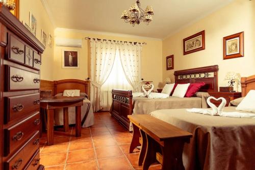 - une chambre avec 2 lits, une table et des chaises dans l'établissement EL SECRETO DE LOS PERALES, à Velada