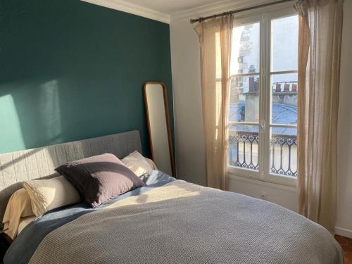 1 dormitorio con 1 cama con ventana y 1 cama sidx sidx sidx sidx en Appartement Paris Marais, en París