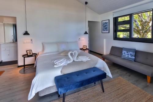 a bedroom with a large bed and a couch at Sublime Tahiti Beach Retreat in Mataiea
