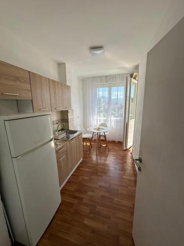 cocina con nevera blanca y mesa en Alex Apartments, en Podgorica
