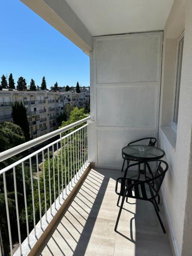 balcón con mesa y vistas a un edificio en Alex Apartments, en Podgorica