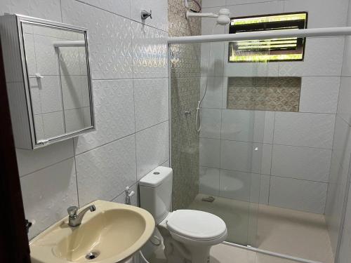 bagno bianco con servizi igienici e lavandino di Casa Barra de São miguel a Barra de São Miguel