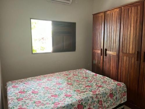 una camera con letto e armadio in legno di Casa Barra de São miguel a Barra de São Miguel