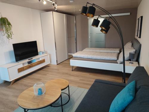 sala de estar con sofá y cama en Kleine Auszeit - 2-Zimmer Ferienwohnung en Spiez