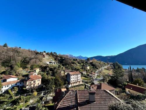 a town on a hill with houses and the water at Elegant apartment inside Villa Fontana in Tremezzo
