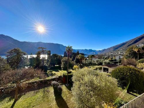 a view of a garden with mountains in the background at Elegant apartment inside Villa Fontana in Tremezzo