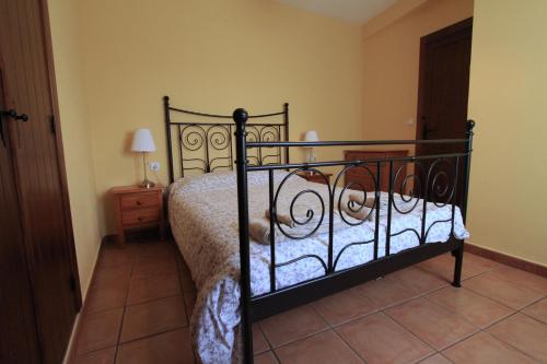 1 dormitorio con cama negra y edredón blanco en La Casita Amarilla, en Los Molinos