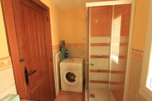 baño con lavadora y puerta en La Casita Amarilla, en Los Molinos