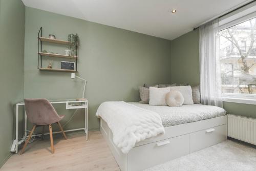1 dormitorio con 1 cama, ventana y escritorio en Newly renovated studio apartment at Frogner, en Oslo