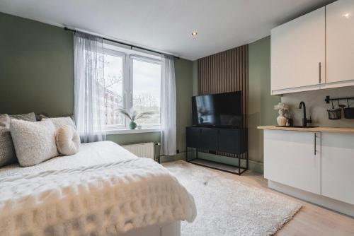 a bedroom with a bed and a flat screen tv at Newly renovated studio apartment at Frogner in Oslo