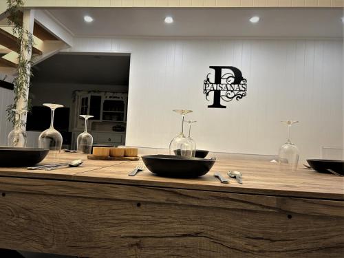 a wooden counter with bowls and wine bottles on it at Paisanas Wisemans Ferry in Wisemans Ferry