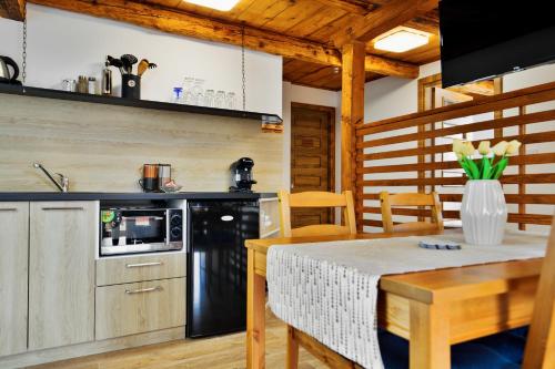 een keuken met een tafel en een zwarte koelkast bij Apartmán Růžák in Růžová