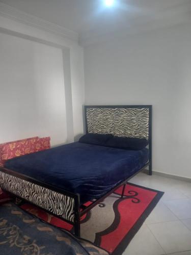 Ce lit se trouve dans un dortoir doté d'une couverture bleue. dans l'établissement résidence miftah sahile, à Zemmour Touirza