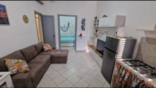sala de estar con sofá y cocina en L'isola di Bea, en Isola delle Femmine