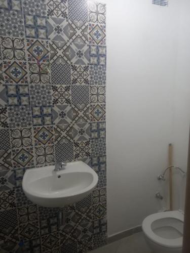 La salle de bains est pourvue d'un lavabo et de toilettes. dans l'établissement résidence miftah sahile, à Zemmour Touirza