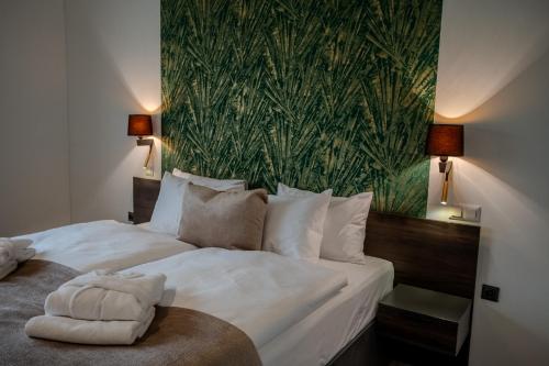 a bedroom with two beds with a green wallpaper at Hotel Golden Palace in Göd