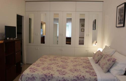 a bedroom with a large bed and a television at Villa Katarina Lošinj Island in Mali Lošinj