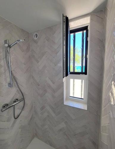 La salle de bains est pourvue d'une douche et d'une fenêtre. dans l'établissement Le Cabanon, pieds dans l'eau, vue exceptionnelle, à Fréjus