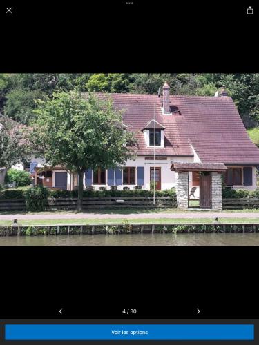 a house with a tree in front of it at Gîte du Flotteur in Chevroches