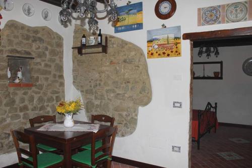 a dining room with a table and a stone wall at Appartamento borgo medioevale Rosa del Castello in Deruta