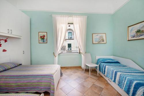 een slaapkamer met 2 bedden en een raam bij Casa Rosaria in Atrani