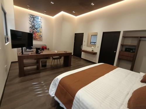 a bedroom with a bed and a desk with a television at Hotel El Salvador in Mexico City