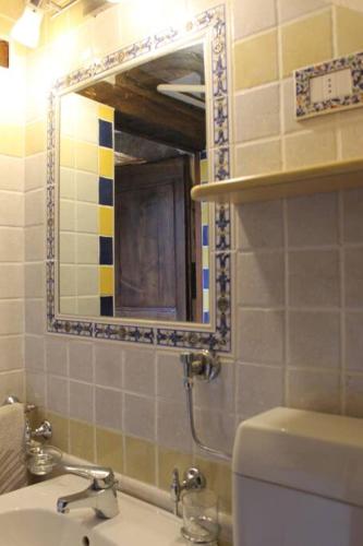 a bathroom with a sink and a mirror and a toilet at Appartamento borgo medioevale Rosa del Castello in Deruta