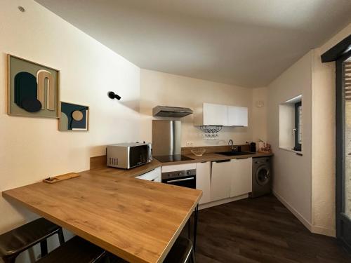 - une cuisine avec une table en bois et un comptoir dans l'établissement La bulle FREBERMIS, à Villeneuve-sur-Lot