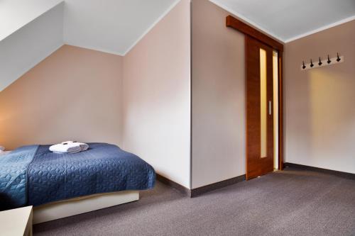 a bedroom with a blue bed and a door at Pension Růžák in Růžová