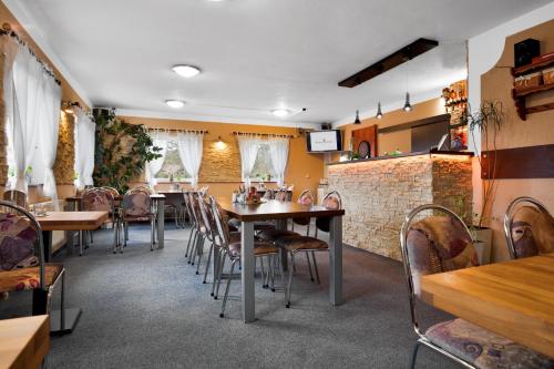 a restaurant with tables and chairs and a brick wall at Pension Růžák in Růžová