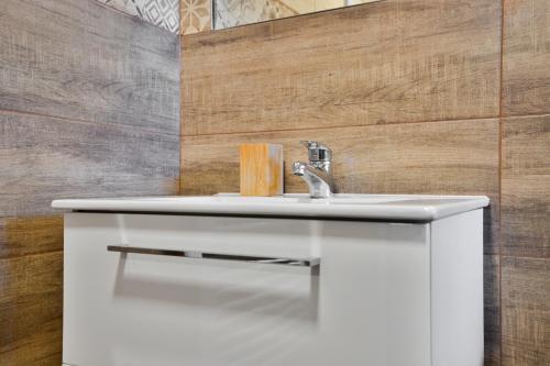 a bathroom with a white sink and wood wall at Pension Růžák in Růžová