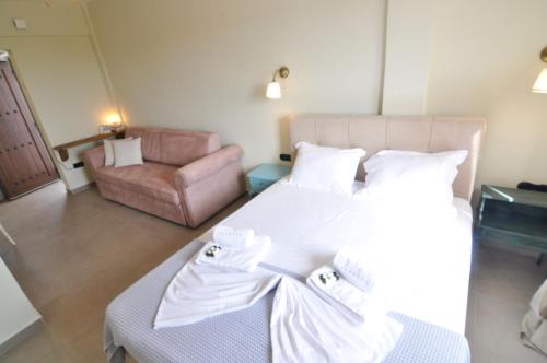 a bedroom with a white bed and a couch at Zennova #61, Boutique Studio in Nikiti in Nikiti