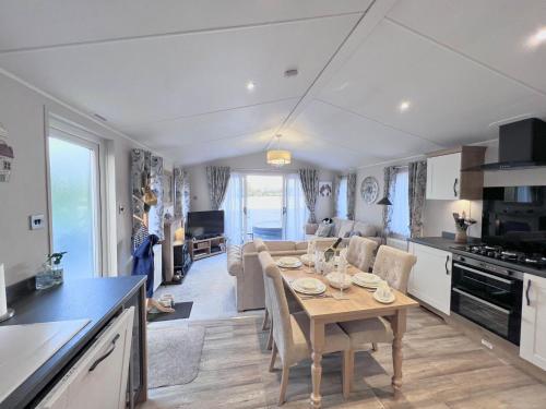 a kitchen and living room with a table and chairs at Lakeside Dorchester Lodge - Hot Tub with Fishing Peg in Tattershall