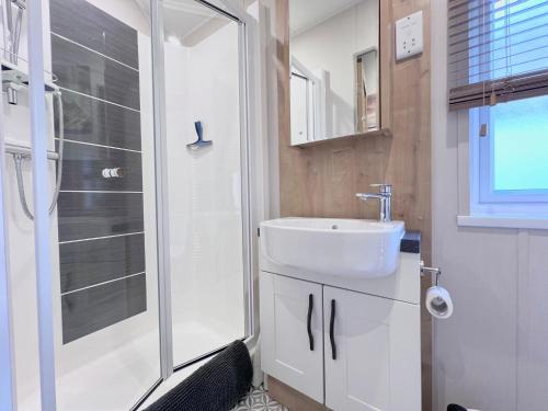 a bathroom with a sink and a shower at Lakeside Dorchester Lodge - Hot Tub with Fishing Peg in Tattershall