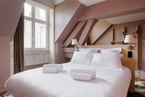 a large white bed with two towels on it at Cloître - Entrée autonome, réception en ligne - Encore Mieux in Orléans