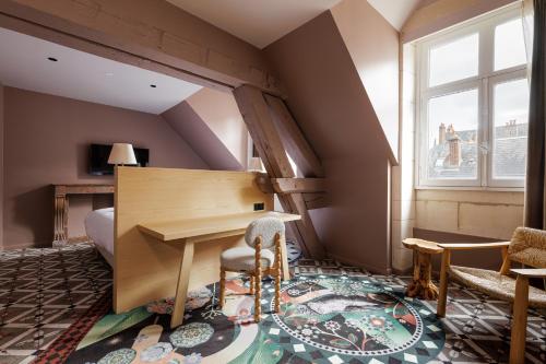 an attic room with a wooden table and chairs at Cloître - Entrée autonome, réception en ligne - Encore Mieux in Orléans