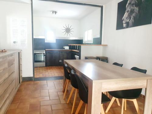 une cuisine et une salle à manger avec une table et des chaises en bois dans l'établissement Villa climatisée avec piscine proche des plages, à La Crau