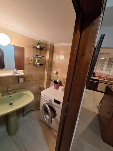 a bathroom with a sink and a washing machine at Valerias house in Aígio