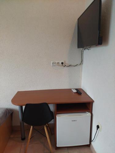 a desk with a computer and a tv on a wall at Royal Apartments in Neum