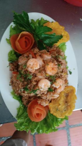 a plate of food with shrimp and lettuce and tomatoes at Manzanillo Beach in Cartagena de Indias