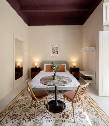 um quarto com uma cama, uma mesa e cadeiras em Birgu No 25 apartment 2 em Birgu