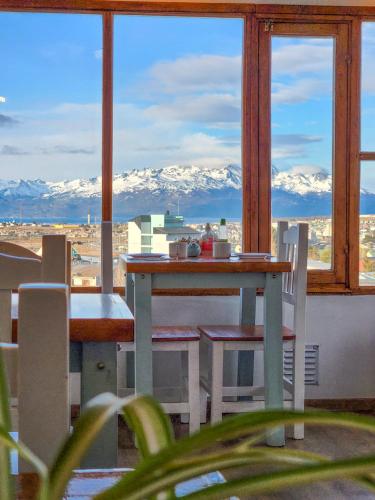a table and chairs on a balcony with a view of mountains at Hostería Aonikenk in Ushuaia