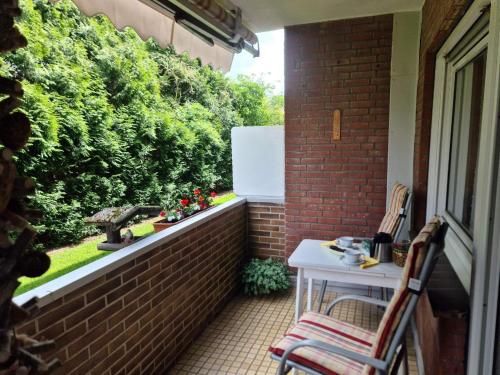 a balcony with a table and chairs on a brick wall at Ferienwohnung "Erika" Rees am Niederrhein in Rees
